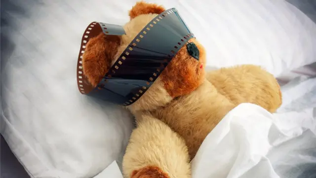 Jouet en peluche avec un rouleau de film autour des yeux