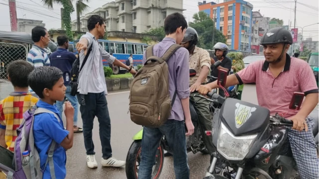 রাস্তায় মোটর সাইকেল আটকে কথা বলছেন ছাত্ররা।