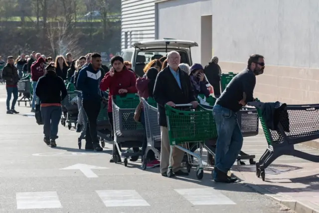 اصطف طابور طويل من الناس أمام سوبر ماركت بالقرب من سان سيباستيان بإسبانيا بعد أن أعلنت الحكومة الإسبانية حالة الطوارئ ونفذت قانون الإغلاق الفوري لجميع الأعمال غير الأساسية حتى 29 مارس/آذار الحالي.