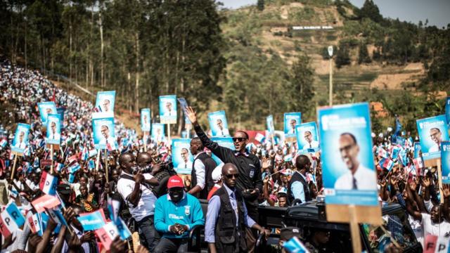 Rwandan President Paul Kagame (C) greets a crowd of supporters holding electoral posters, as he arrives for a rally in Gakenke, on 31 July 2017