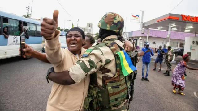 Une femme embrasse un soldat alors qu'elle fait la fête avec des personnes soutenant un putschiste, dans une rue de Port-Gentil, au Gabon, le 30 août 2023.
