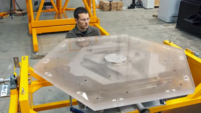 Técnico con uno de los segmentos hexagonales del espejo