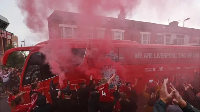 Liverpool fans applaud the team bus
