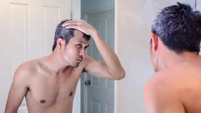 Homem se olha no espelho