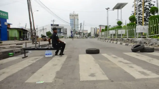 Seorang polisi memblokir jalan masuk ke kota Lagos, yang menerapkan karantina wilayah selama dua pekan.