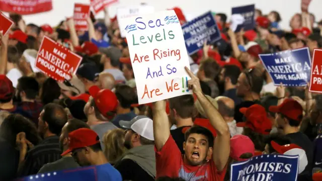 一名示威者在哈里斯堡的特朗普支持者集会上举起抗议标语。