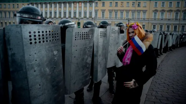 Девушка с российским флагом и много омоновцев