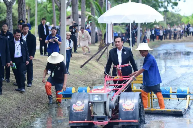พล.อ.ประยุทธ์ทดลองขับรถเครื่องยอดเมล็ดพันธุ์ข้าวในแปลงสาธิต ที่จ.สุพรรณบุรี โดยมีนักเรียนเกษตรกรรุ่นที่ 1 คอยเป็นพี่เลี้ยง