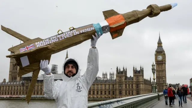 یک عضو عفو بین‌المللی در حال اعتراض به فروش تسلیحات بریتانیا به یمن در نزدیکی پارلمان بریتانیا