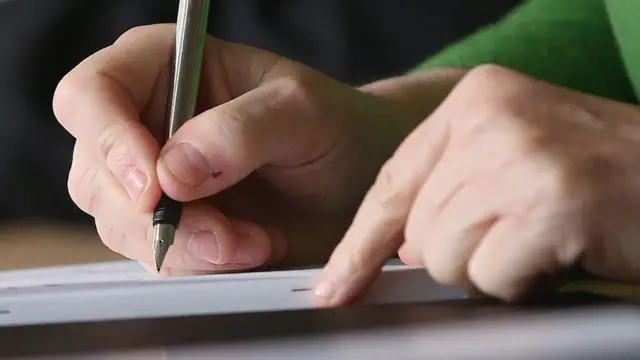 شخص يكتب بقلم