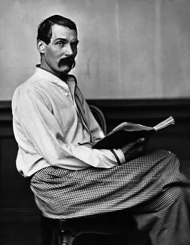 Richard Burton con un gran bigote y un libro.