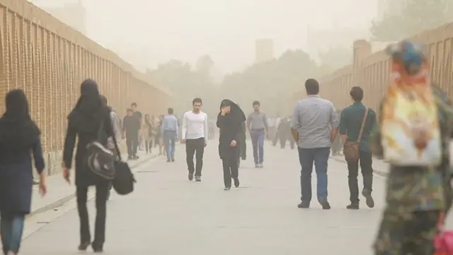 مردم در حال رفت و آمد در هوای آلوده اصفهان