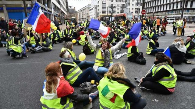 Mujeres vestidas con un chaleco amarillo organizan una protesta en Francia.