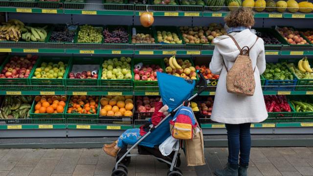 Mulher com bebê escolher frutasroleta de 1 a 10mercado