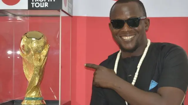 Arakunrin kan to wa lara awọn ololufẹ bọọlu to wa wo ife ẹyẹ agbaye n ya fọto pẹlu ife ẹyẹ naa