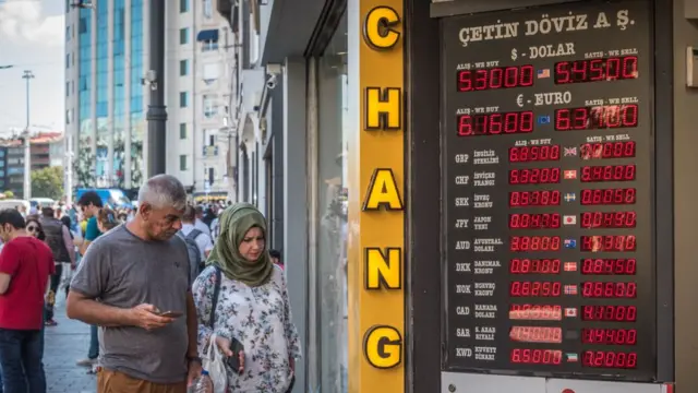 Люди у пункта обмена валюты в Стамбуле