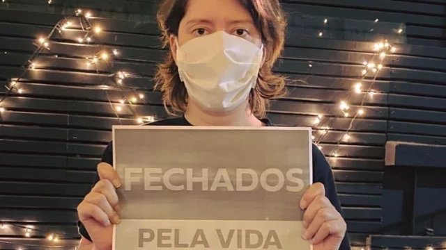 Jana,site apostas politicamáscara, segura placa dizendo: "Fechados pela vida"