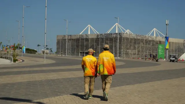 Voluntários caminham para o Estádio Aquático Olímpico no Parque Olímpico