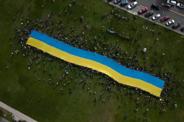 Протестующие с гигантским украинским флагом в Анкоридже, Аляска, 15 августа 2025 года во время российско-американского саммита