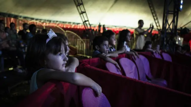 Menina aguarda a entrada dos palhaços Patati Patatá