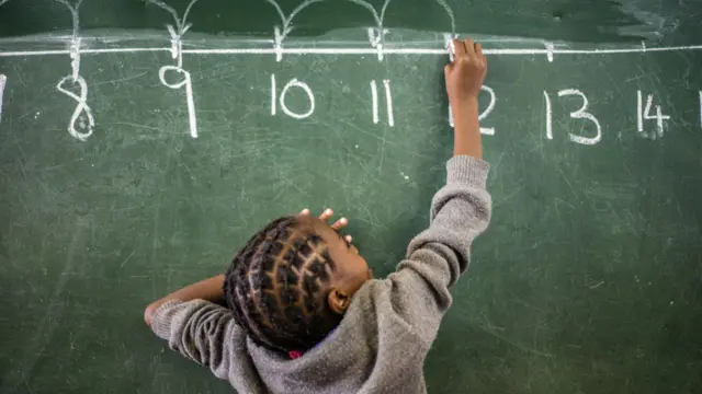 Niña escribiendo número en una pizarra