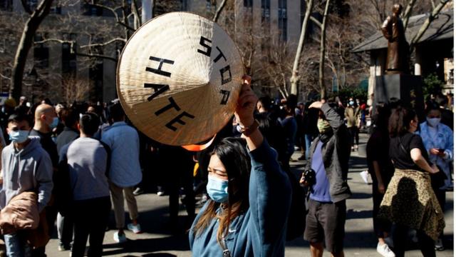 Một phụ nữ giơ cao chiếc nón Việt với dòng chữ "Stop Hate" (chấm dứt thù hằn) tại công viên Columbus, Chinatown, New York ngày 21/3/2021