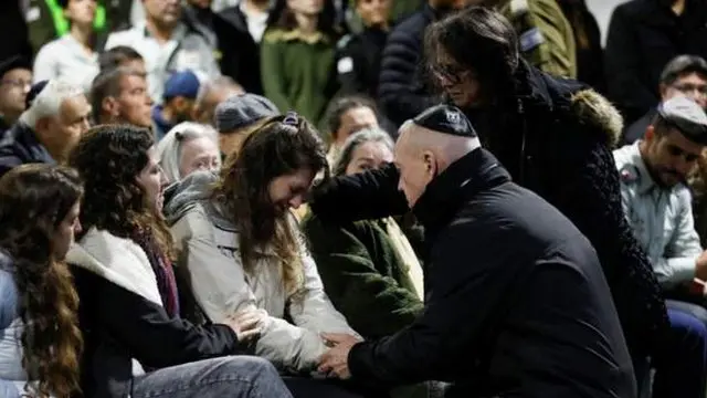 死亡した兵士の妻の手を取るヨアヴ・ガラント国防相（13日）