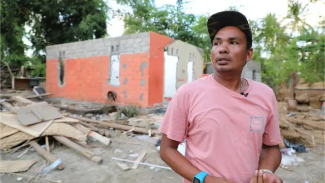 Damar di depan puing-puing yang dulu rumahnya