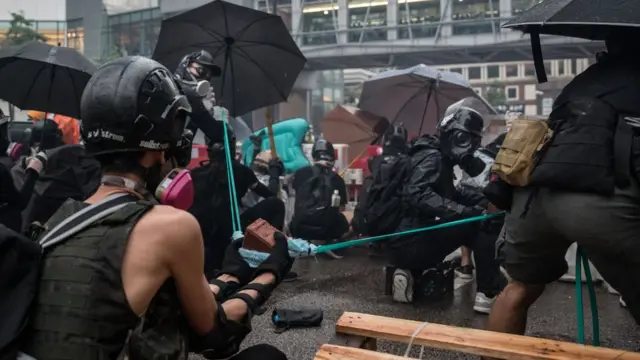 示威者用弹弓向警察防线发射砖头。