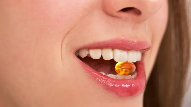 సప్లిమెంట్ పిల్ తీసుకుంటున్న మహిళ