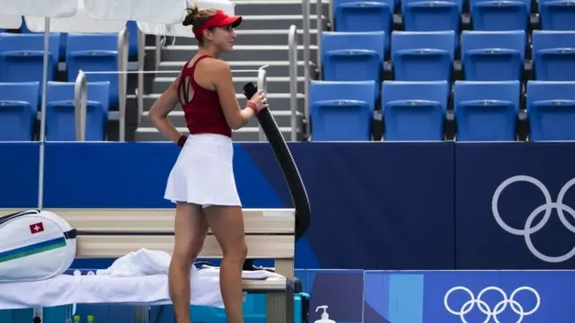 Belinda Bencic of Switzerland enjoys cool air out of a tube during her second round match against Misaki Doi of Japan