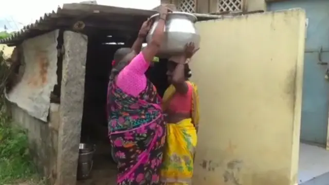 சூடான சமையல் பாத்திரத்தை சுமக்கும் பணியாளர்