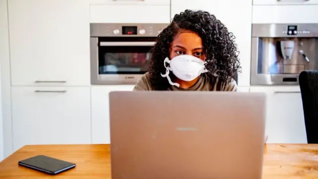 فتاة تستخدم الكمبيوتر المحمول في منزلها