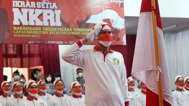 Seorang narapidana tindak pidana khusus terorisme memberi hormat bendera merah putih saat ikrar setia kepada Negara Kesatuan Republik Indonesia (NKRI) di Lapas Narkotika Kelas IIA Gunung Sindur, Kabupaten Bogor, Jawa Barat, Selasa (9/11/2021)