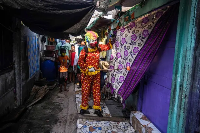 موظف الخدمة الاجتماعية آشوك جاغاناث كورمي يرش مواد معقمة وهو يرتدي ملابس المهرج في أحد أحياء مومباي الفقيرة في الهند في محاولة لوقف انتشار فيروس كورونا.