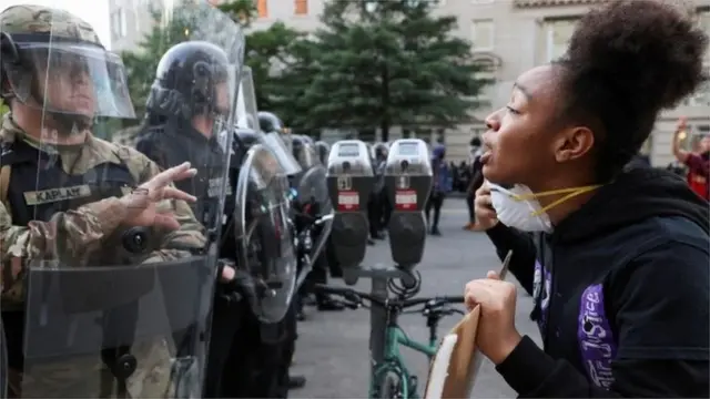 A demonstrator faces law enforcement officers during a rally near the White House
