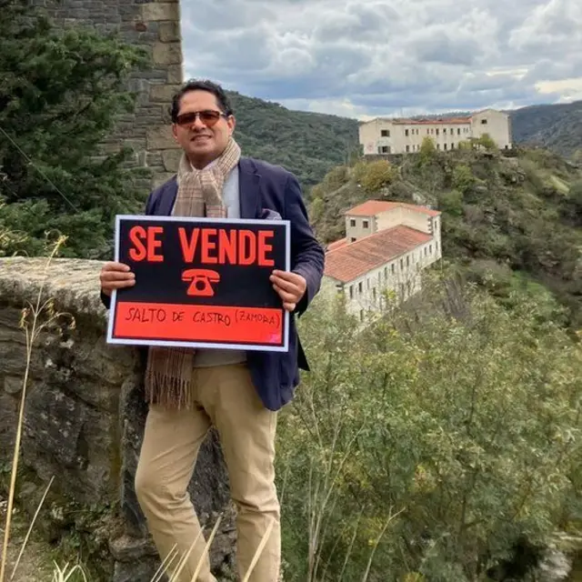 Ronnie Rodríguez, holding a "for sale" sign, says the owner wanted to set up a hotel in the village