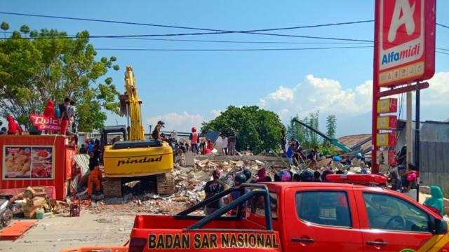 Warga mengambil makanan dari 'minimarket' yang ambruk di Palu, Sulawesi Tengah, Minggu (30/9). Warga terpaksa mengambil karena mereka juga membutuhkan makanan dan air bersih.