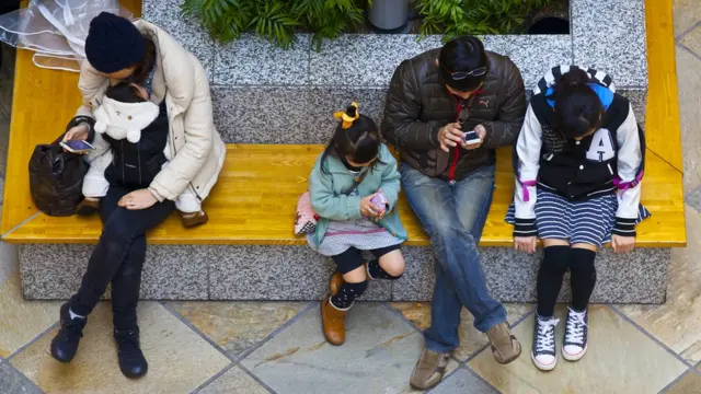 Japanese people looking at phone screens