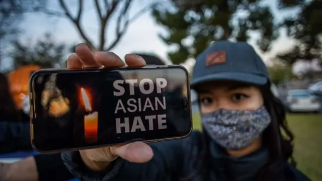 Julie Tran holds her phone during a candlelight vigil in Garden Grove, California, on March 17, 2021 to unite against the recent spate of violence targeting Asians
