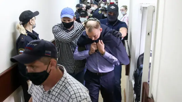 Иван Сафронов (в центре) в коридоре суда в сопровождении конвойных