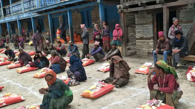 कर्णाली प्रदेशको डोल्पा जिल्लास्थित ठूलीभेरी नगरपालिकाका स्थानीय बासिन्दाहरू नगरपालिकाले उपलब्ध गराएको खाद्यसामग्री उपलब्ध बुझ्दै। कोरोनाभाइरस रोकथामका लागि लकडाउन लगाइएपछि नेपालका विभिन्न स्थानमा खाद्यपदार्थ र उपभोग्य सामग्री पाउन कठिन भएको गुनासो सुनिएको छ।