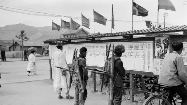 1952년 지게를 지고 최초의 지방선거 안내문을 보고 있는 사람들