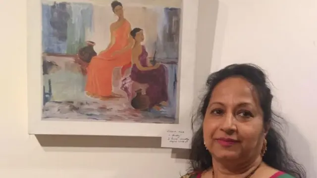 প্রদর্শনীতে নিজের আঁকা ছবির সামনে শিল্পী এলহাম খুকু