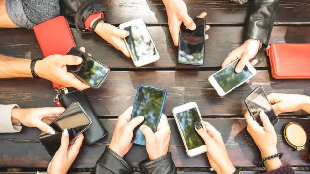 varias personas agarrando su celular.