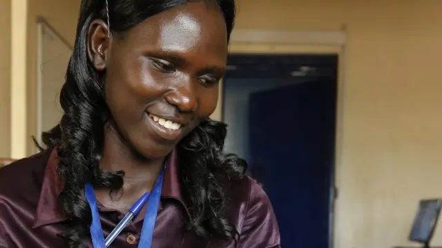 Employée qui sourit dans son entreprise.