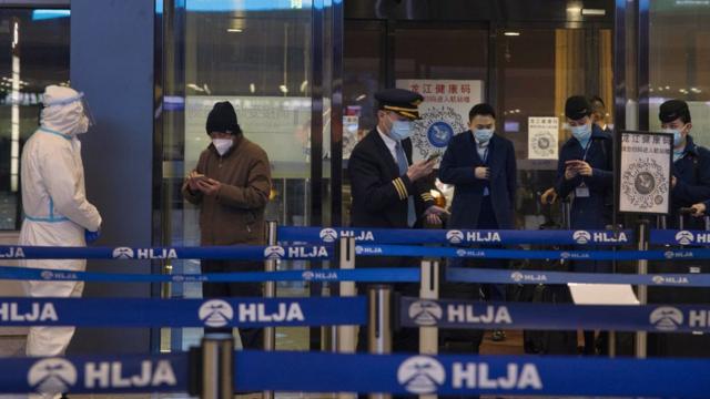 中国黑龙江哈尔滨太平国际机场进港机组人员与旅客向检疫人员出示手机健康码（15/1/2021）