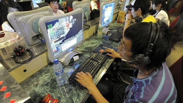 Un joven usa una computadora en un cibercafé.