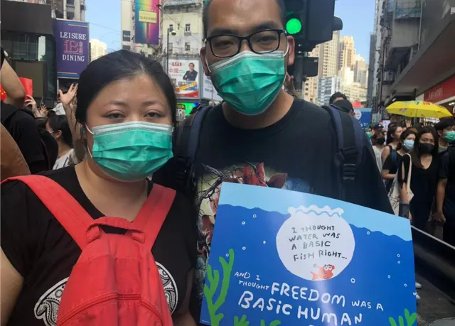 34岁的Lisa与丈夫Tony手持标语,写上"水是基本鱼权,自由是基本人权"。