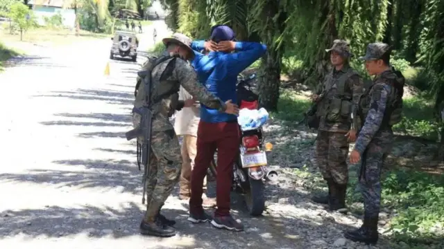 Soldados revisan a un vecino de El Estor.